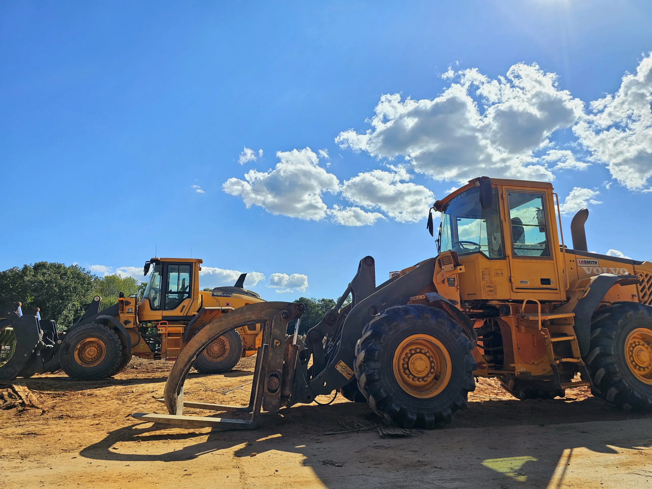 Volvo front loaders at Turman Forest Products lumber yard in Virginia, used for hardwood sawmill and logging operations under sustainable forestry practices.