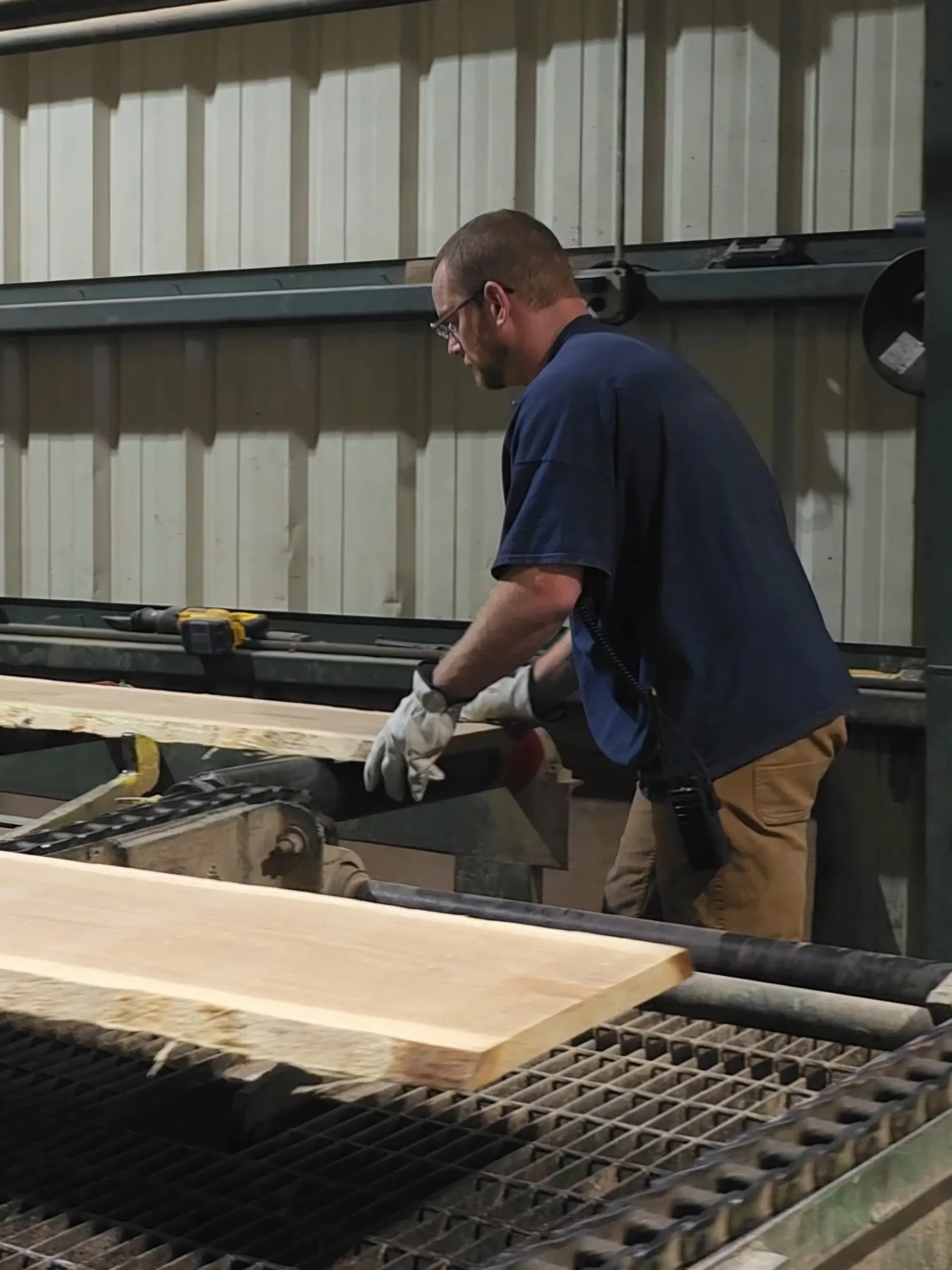 Employee operating sawmill machinery to process Appalachian hardwood lumber at Turman Forest Products, part of The Turman Group’s sustainable forestry operations in Virginia.